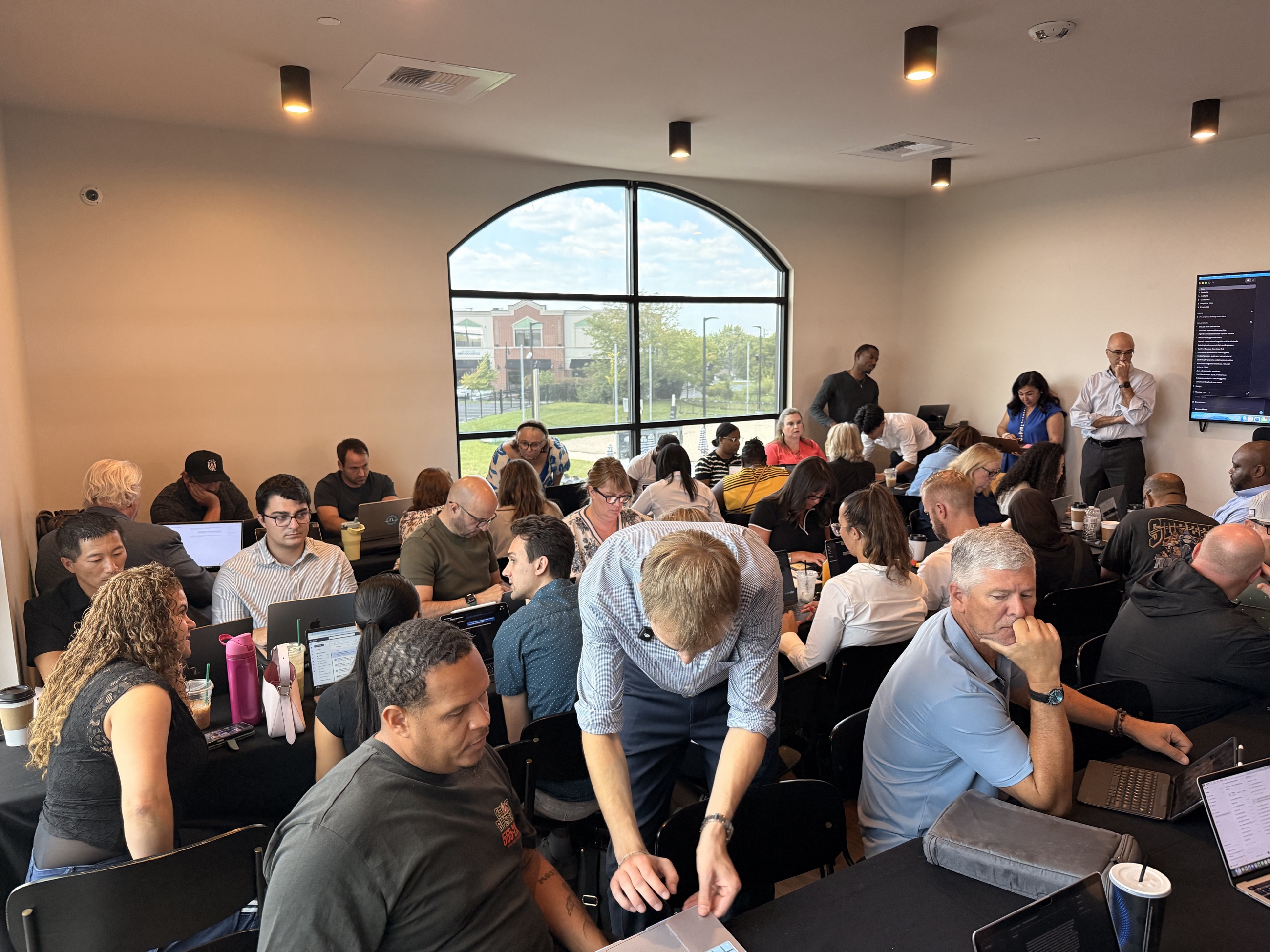 Attendees working together with their laptops at the previous AI workshop